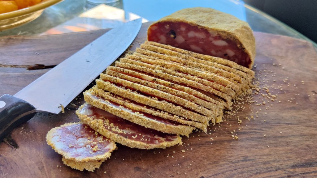 Pitina cut into slices on a nice wooden plate